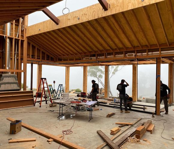 A group of men are working on a large wooden structure.