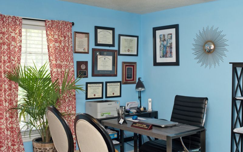 A room with blue walls and a desk with a laptop on it