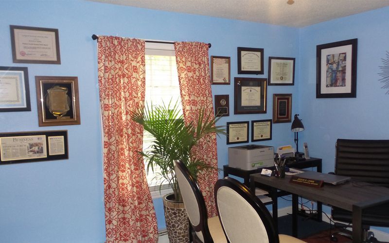A room with blue walls and a desk and chairs