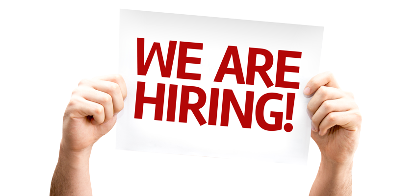 A person is holding a sign that says `` we are hiring ''.