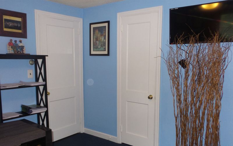 A living room with blue walls and white doors