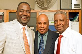 Three men in suits and ties are posing for a picture