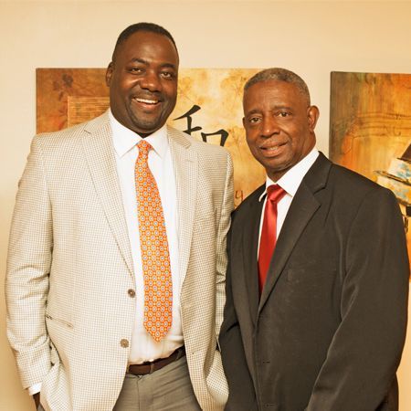 Two men in suits and ties are posing for a picture