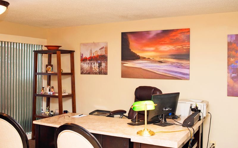 A desk with a green lamp and a computer on it