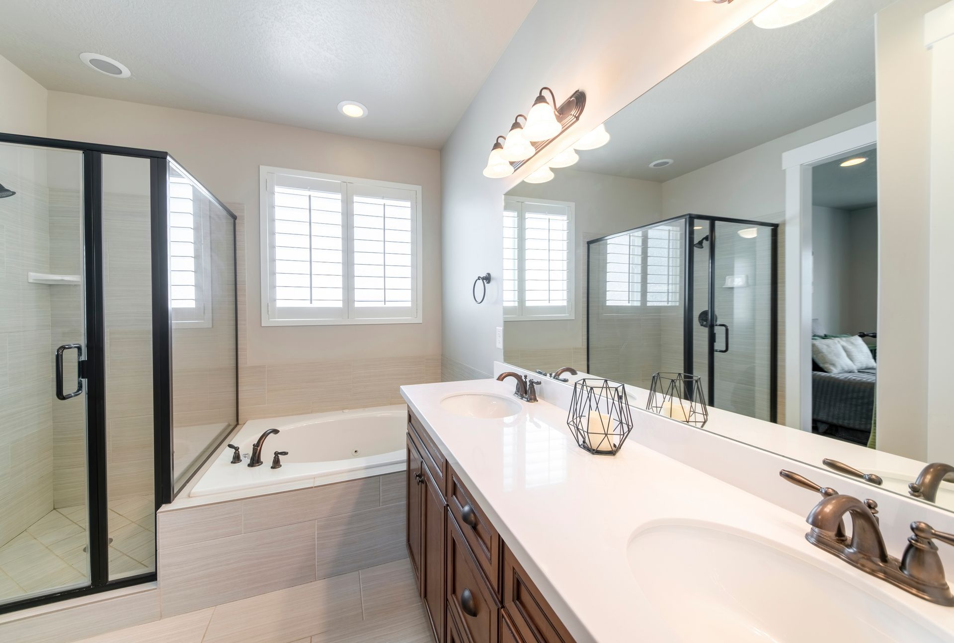 Bright bathroom with glass shower, soaking tub, double vanity, and large mirror
