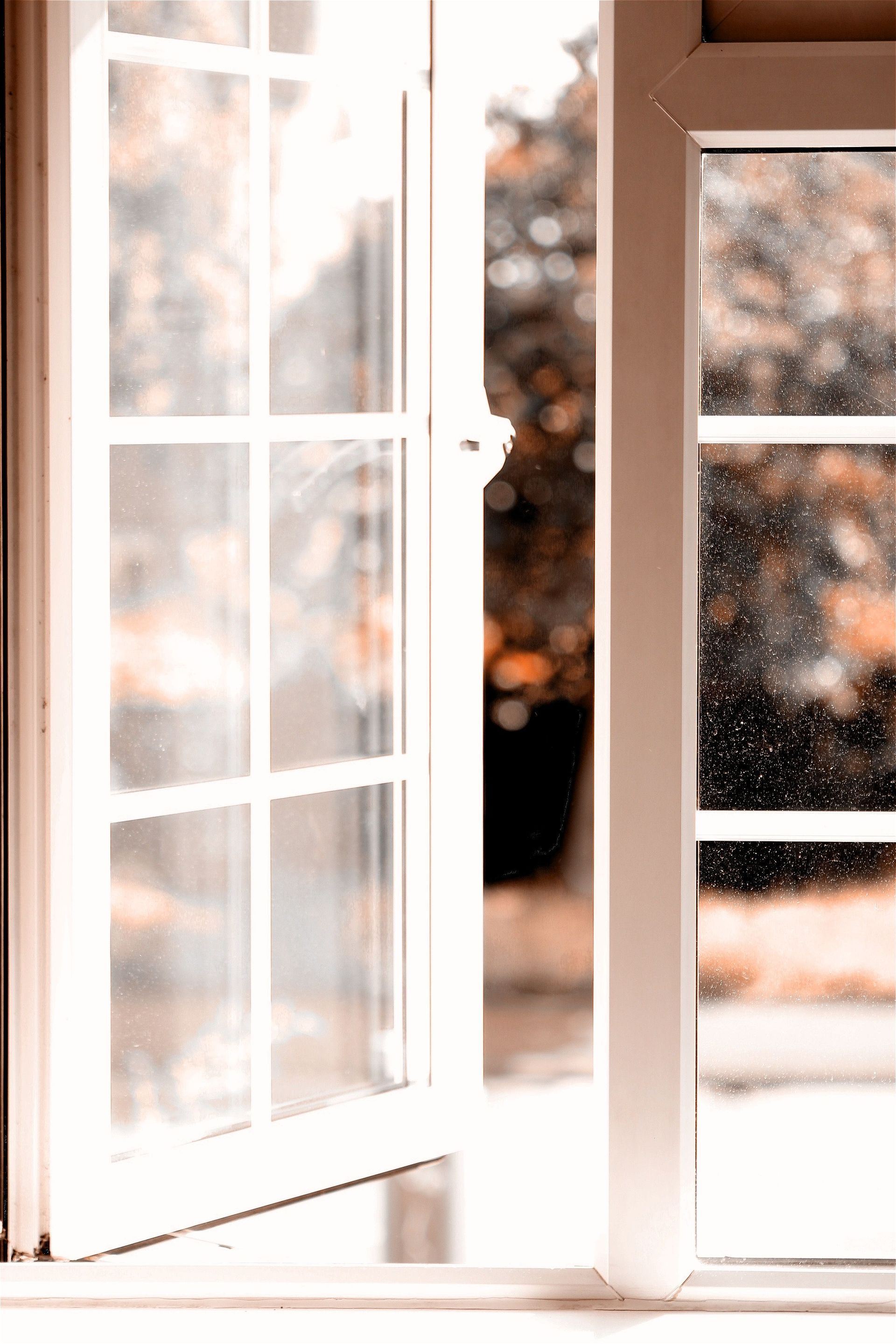 Open white French doors with soft sunlight streaming into a blurred room