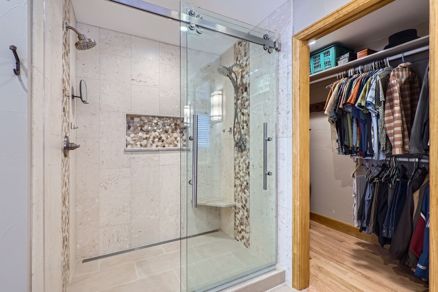 Bathroom with white marble walls, black marble countertop, white sink, and shower.