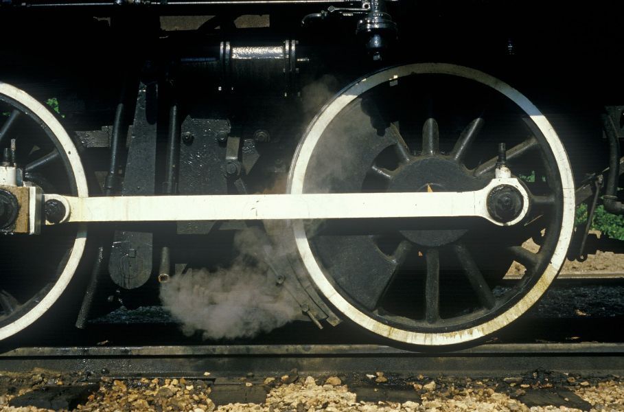 a close up of a train wheel with smoke coming out of it