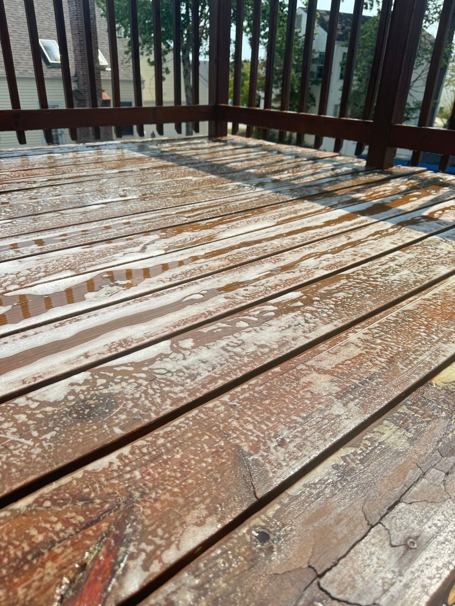 Weathered wooden deck with peeling paint and railings.