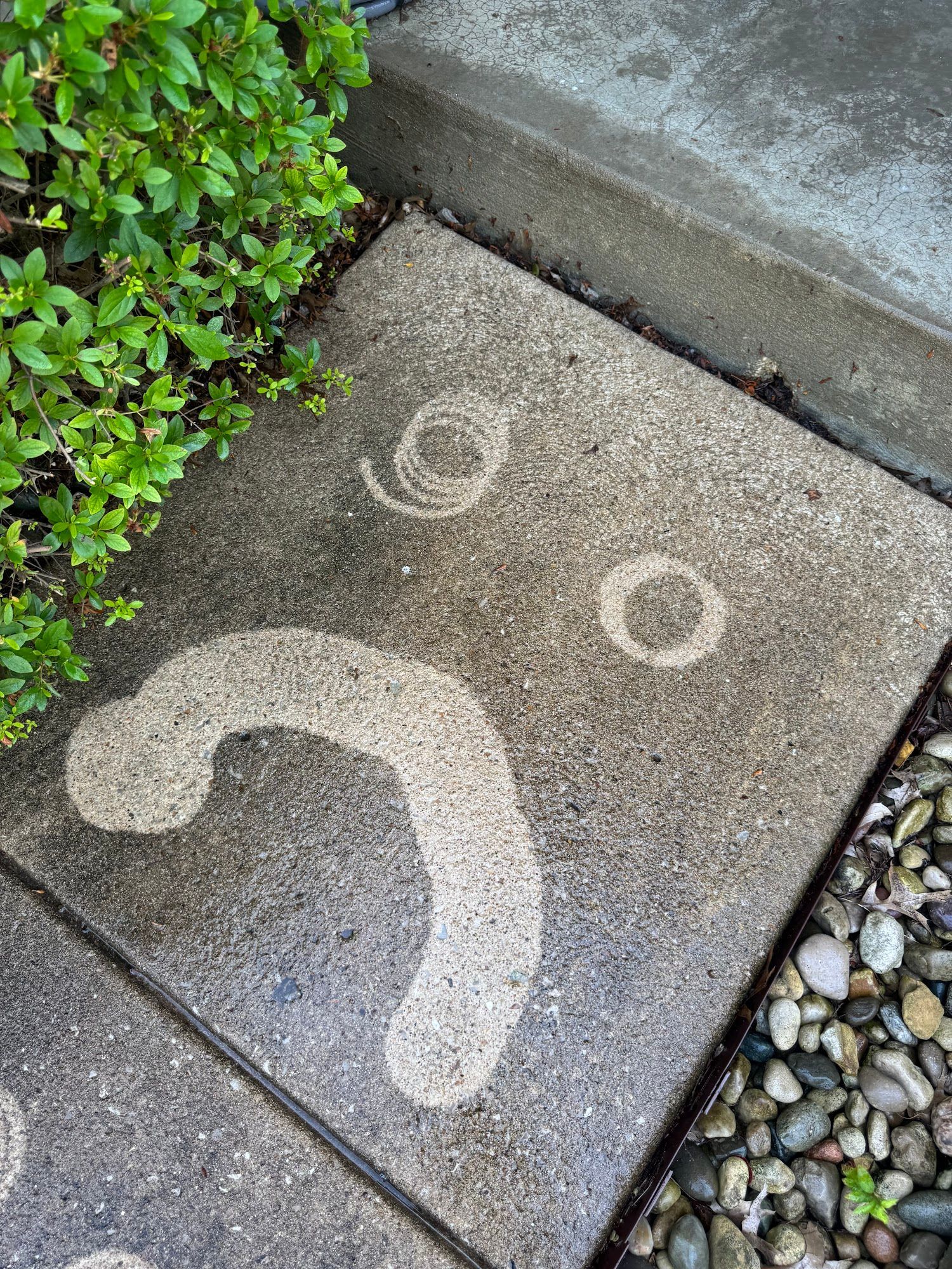 Sad face design made with cleaning on a sidewalk.