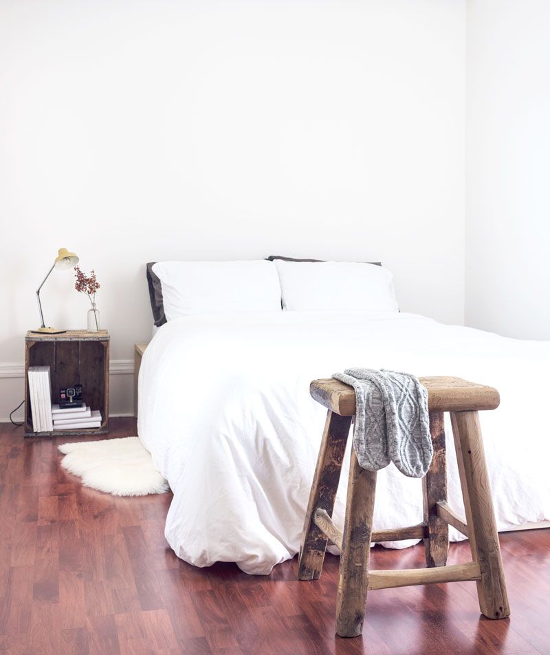 A Bedroom with A Bed and A Wooden Stool — Maid In Bowral in Moss Vale, NSW