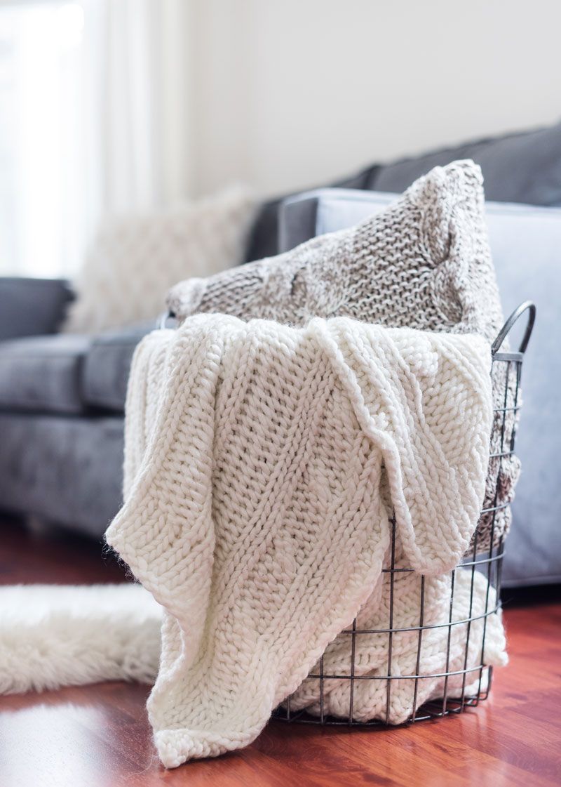 A Basket Filled with Blankets and Pillows in A Living Room — Maid In Bowral in Moss Vale, NSW