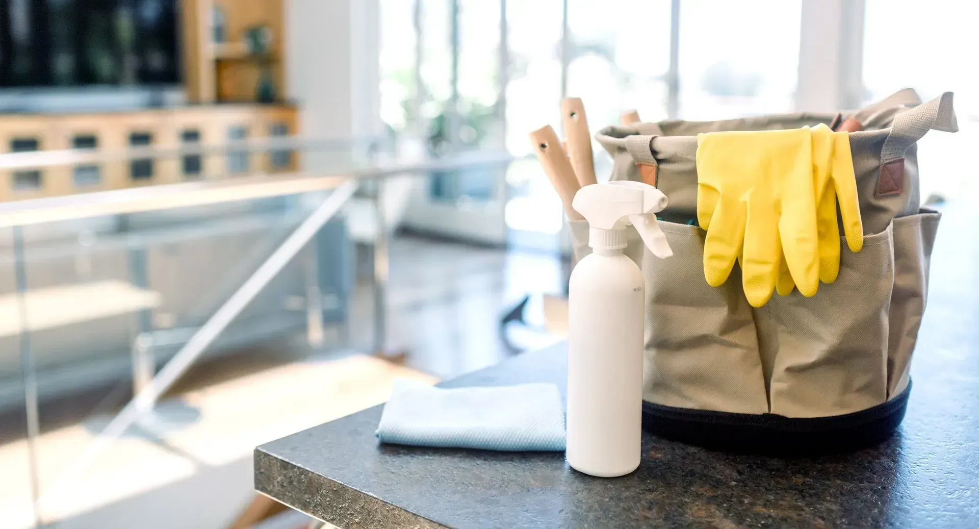 A Kitchen Counter with A Spray Bottle , Gloves , and A Basket of Cleaning Supplies — Maid In Bowral in Moss Vale, NSW