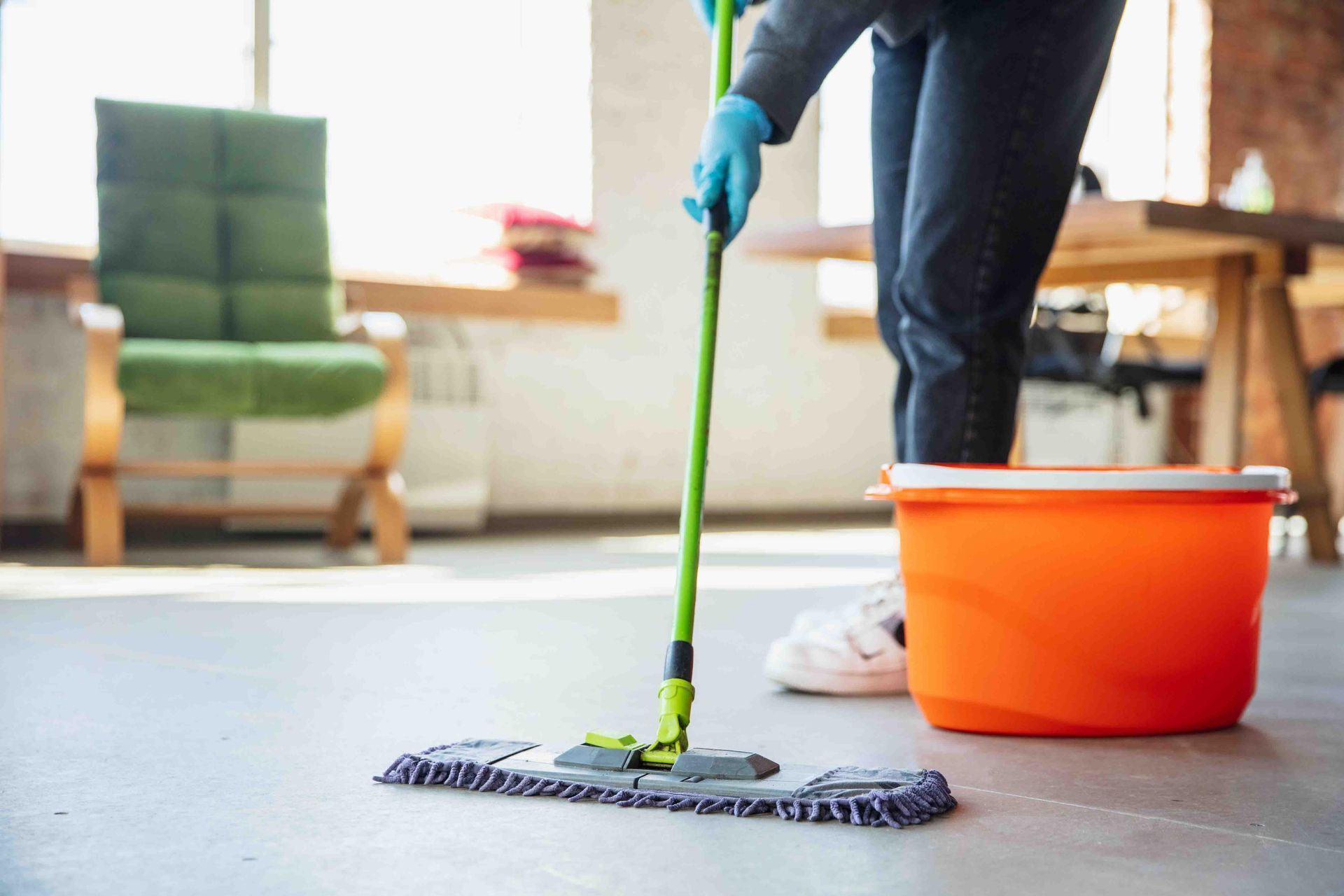 A Person Is Cleaning the Floor with A Mop and Bucket — Maid In Bowral in Moss Vale, NSW