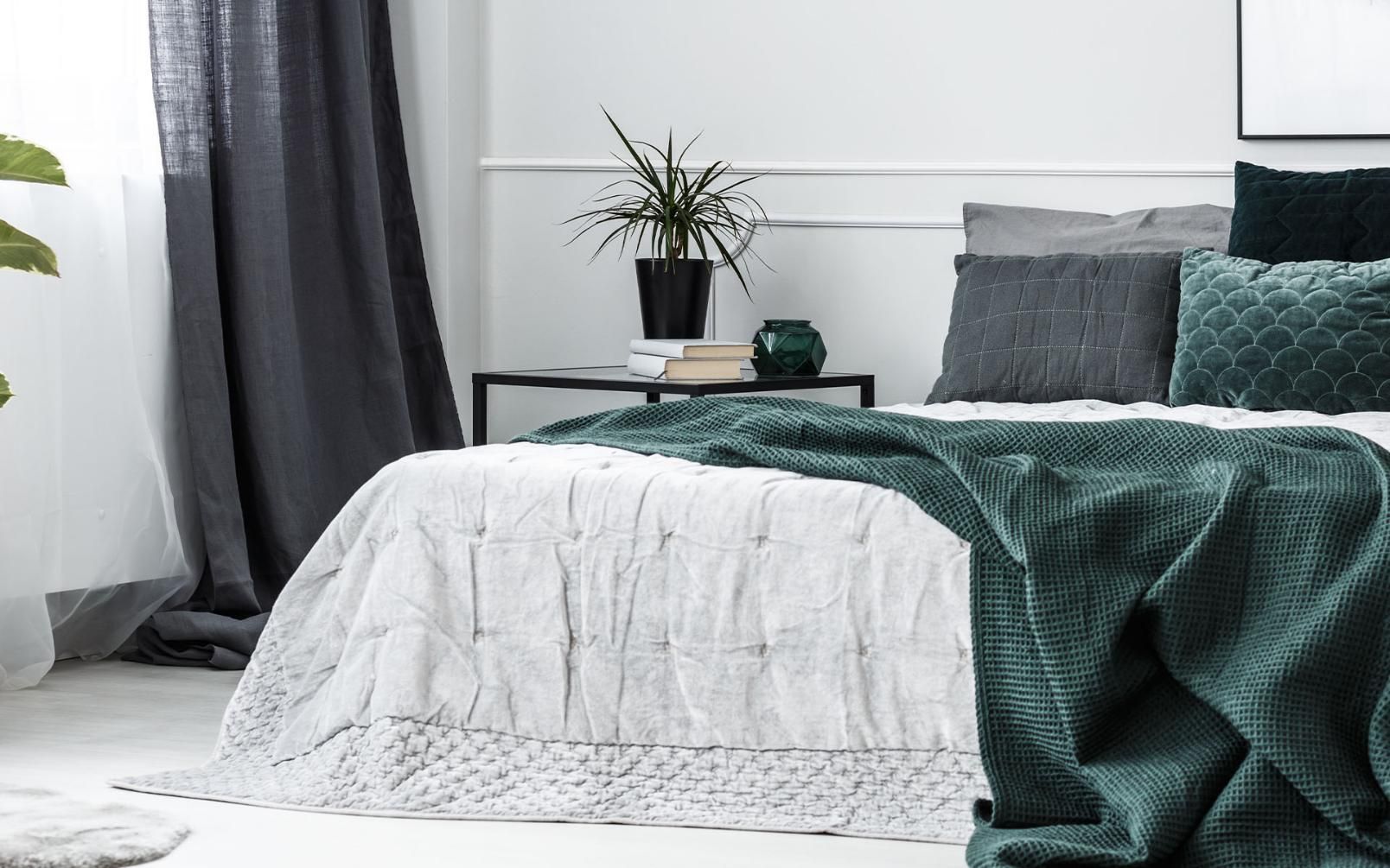 A Bed with A Green Blanket and Pillows in A Bedroom — Maid In Bowral in Moss Vale, NSW