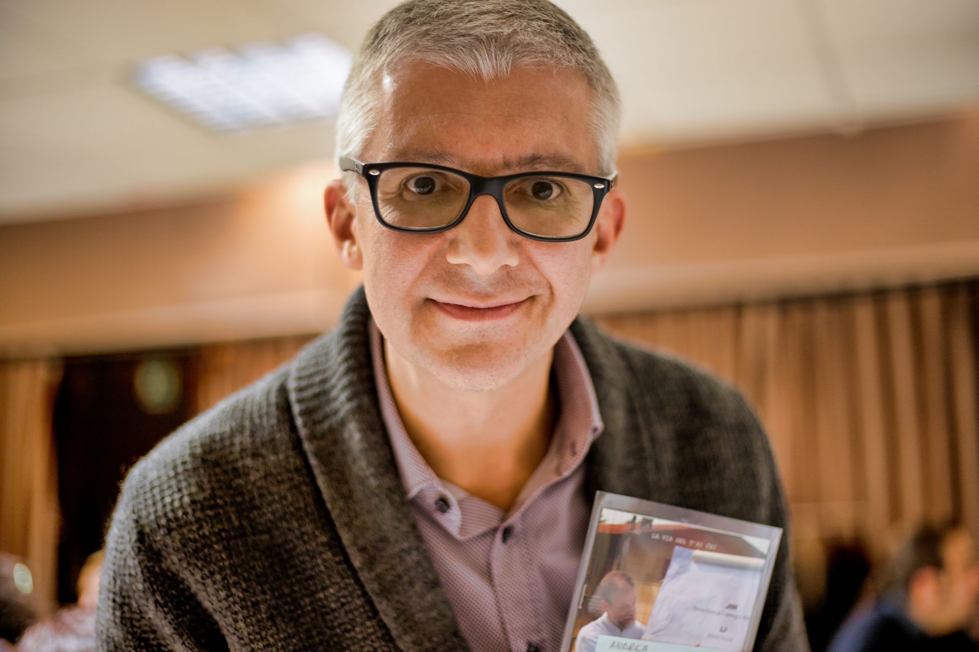 un uomo con gli occhiali tiene in mano un biglietto da visita: Andrea Brugnoli