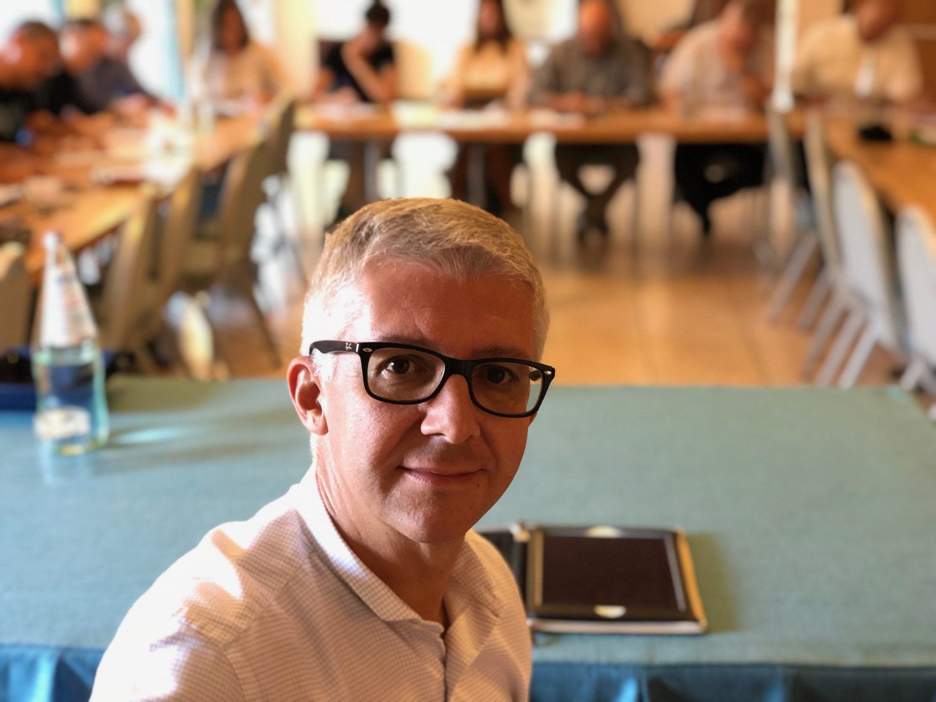 un uomo con gli occhiali è seduto a un tavolo: Andrea Brugnoli