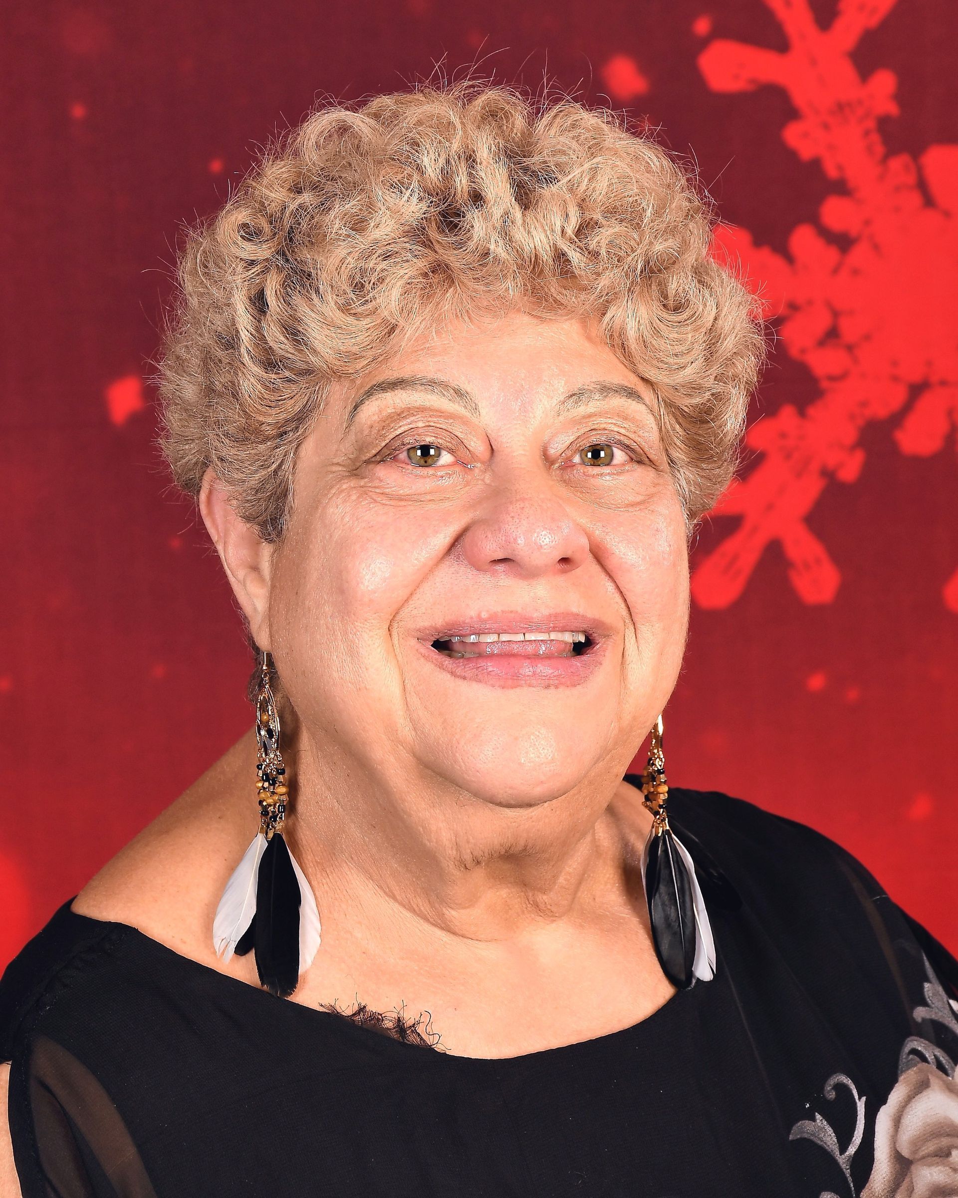 A woman wearing glasses and a blue shirt is smiling for the camera.