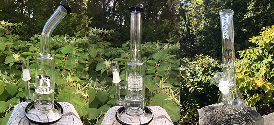 Three glass bongs are sitting on top of a rock