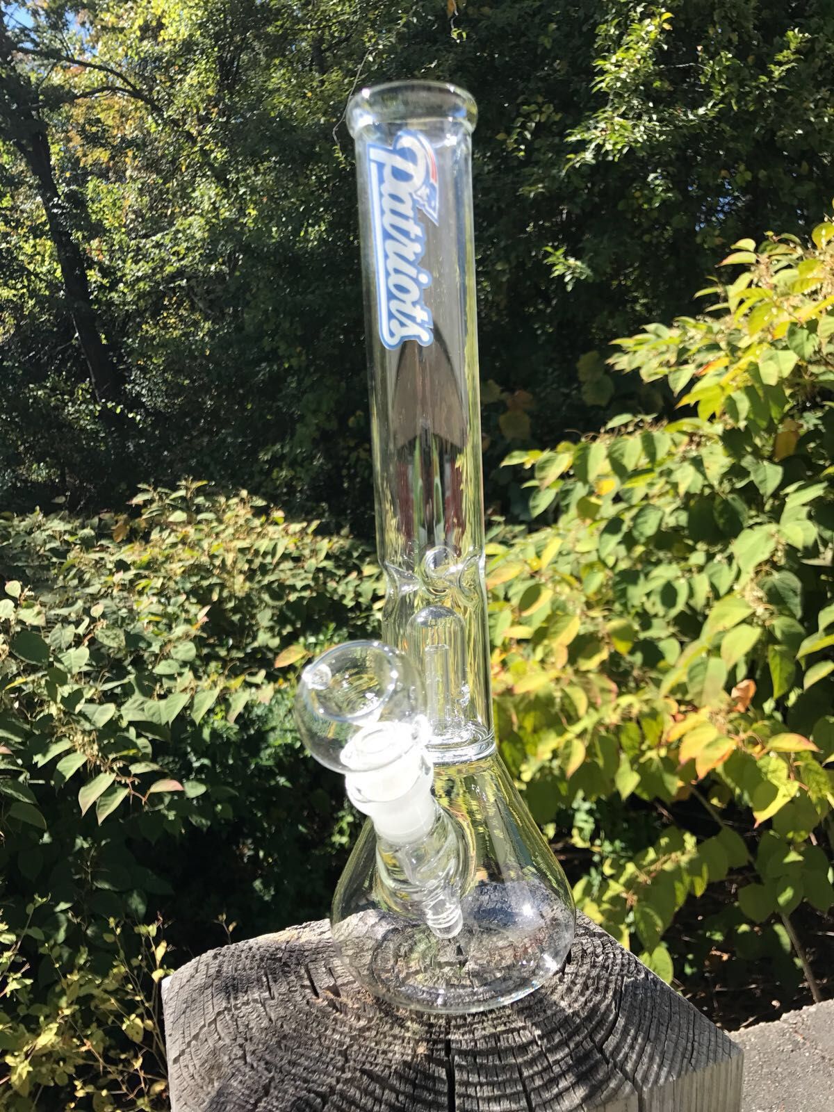 A glass bong is sitting on top of a piece of wood