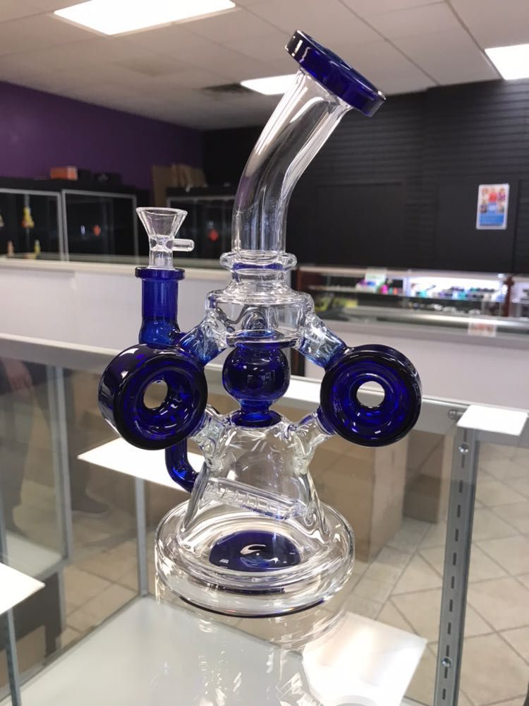 A blue glass pipe is sitting on a glass shelf in a store