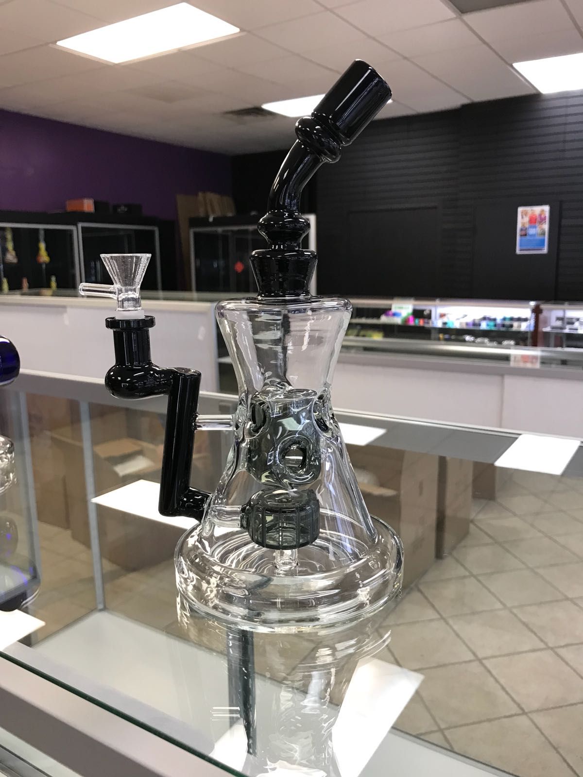 A glass pipe is sitting on a glass table in a store