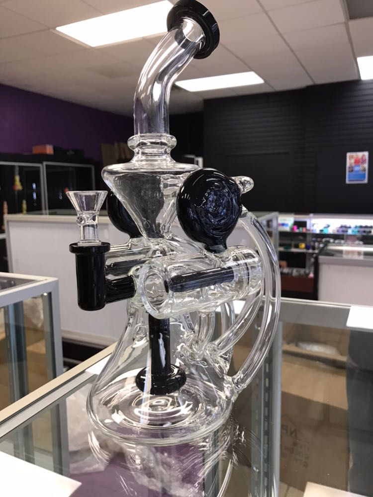 A glass pipe is sitting on top of a glass display case in a store