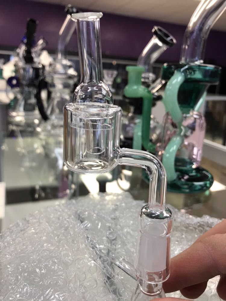 A person is holding a glass pipe in their hand in a store