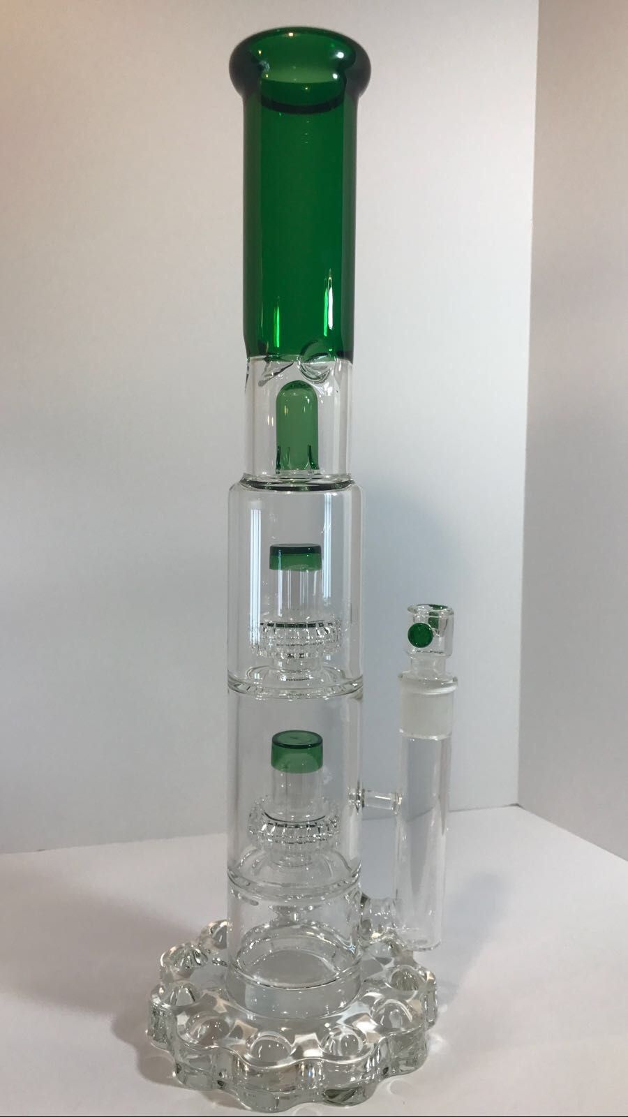 A green glass bong is sitting on top of a white table