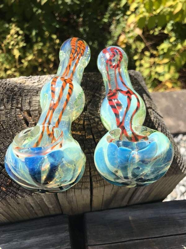 Two glass pipes are sitting on a piece of wood