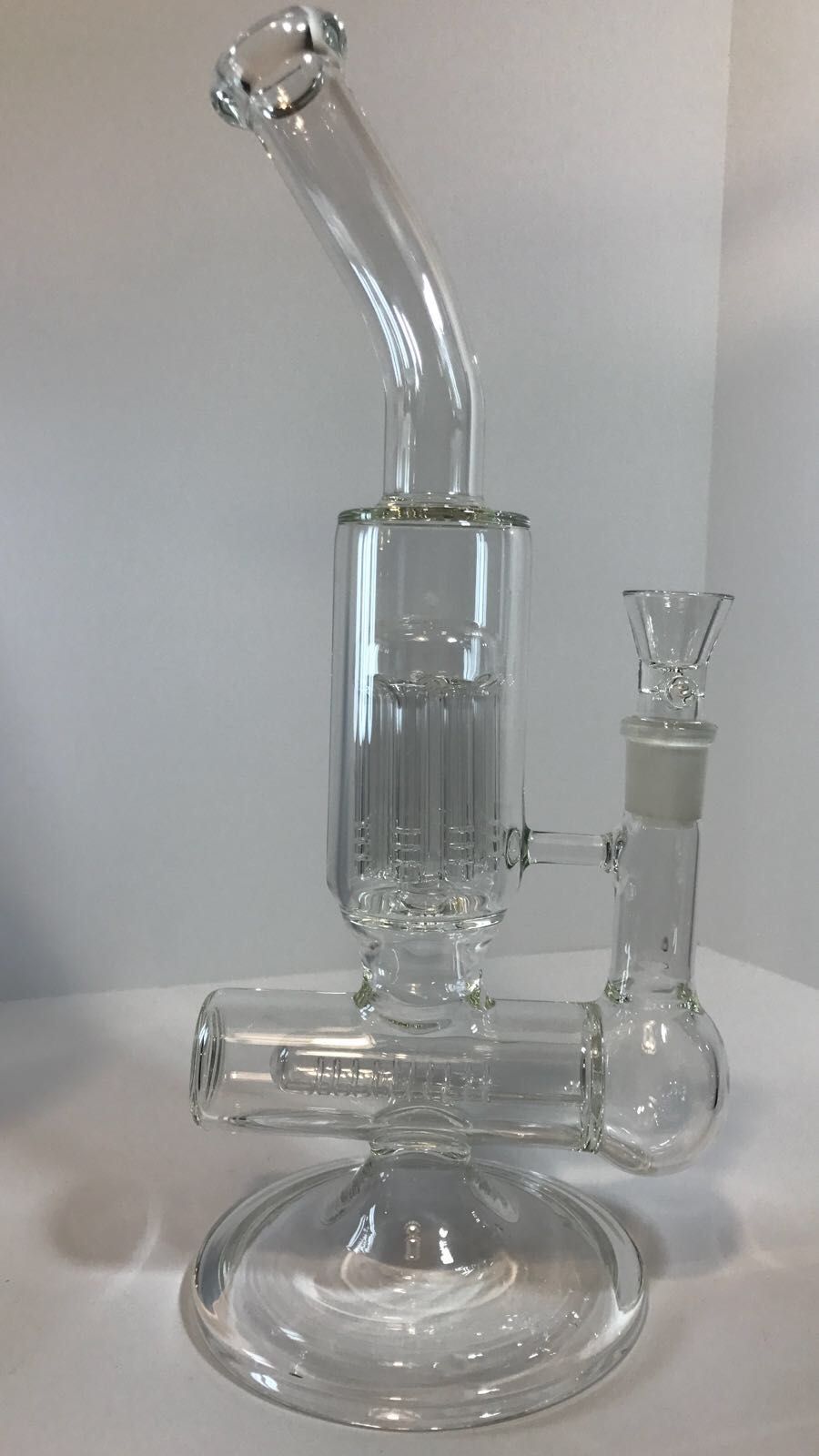 A clear glass bong is sitting on top of a white table