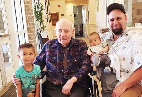 a man in a wheelchair is posing for a picture with two children .