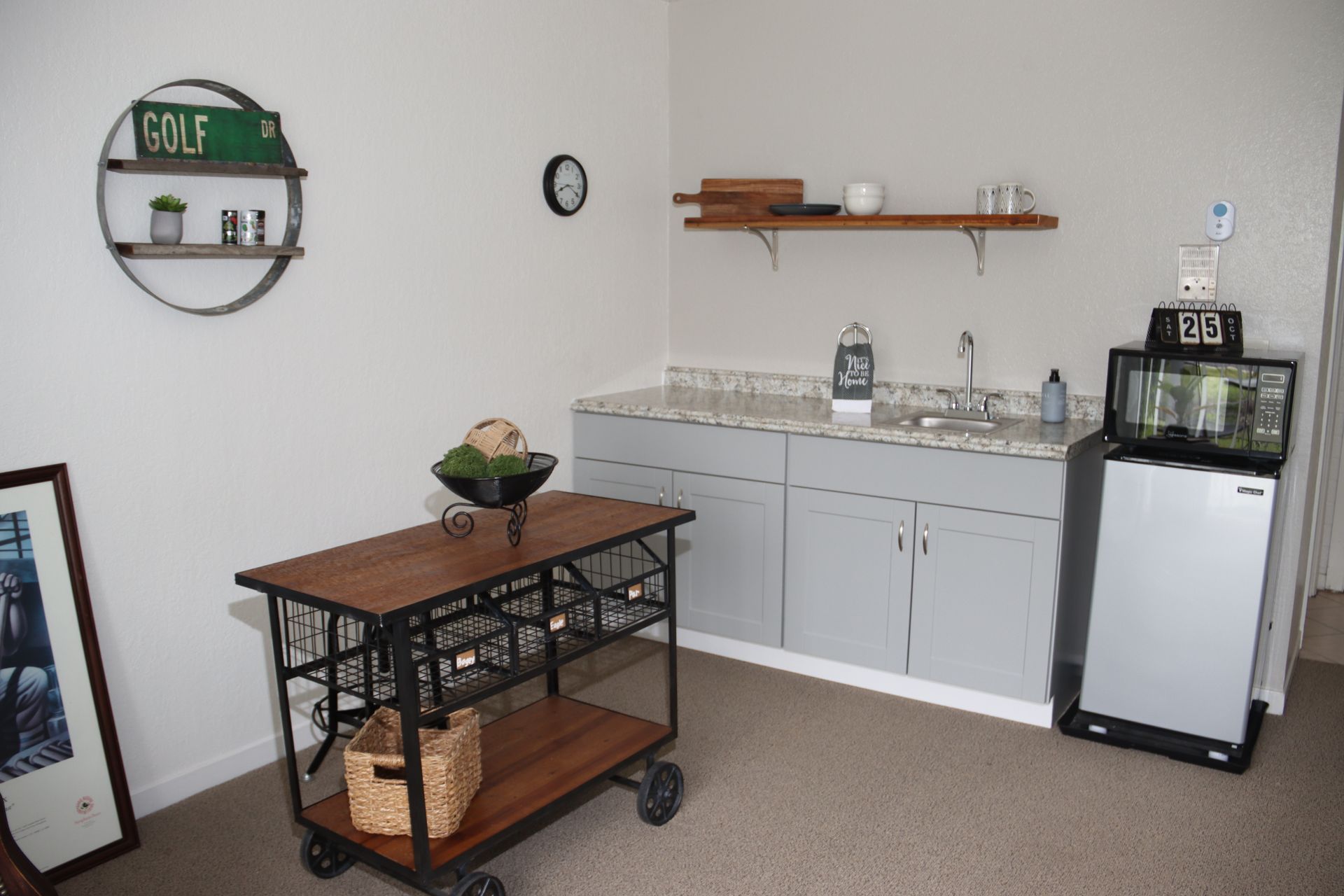 A white brick house with a porch with chairs and a table.