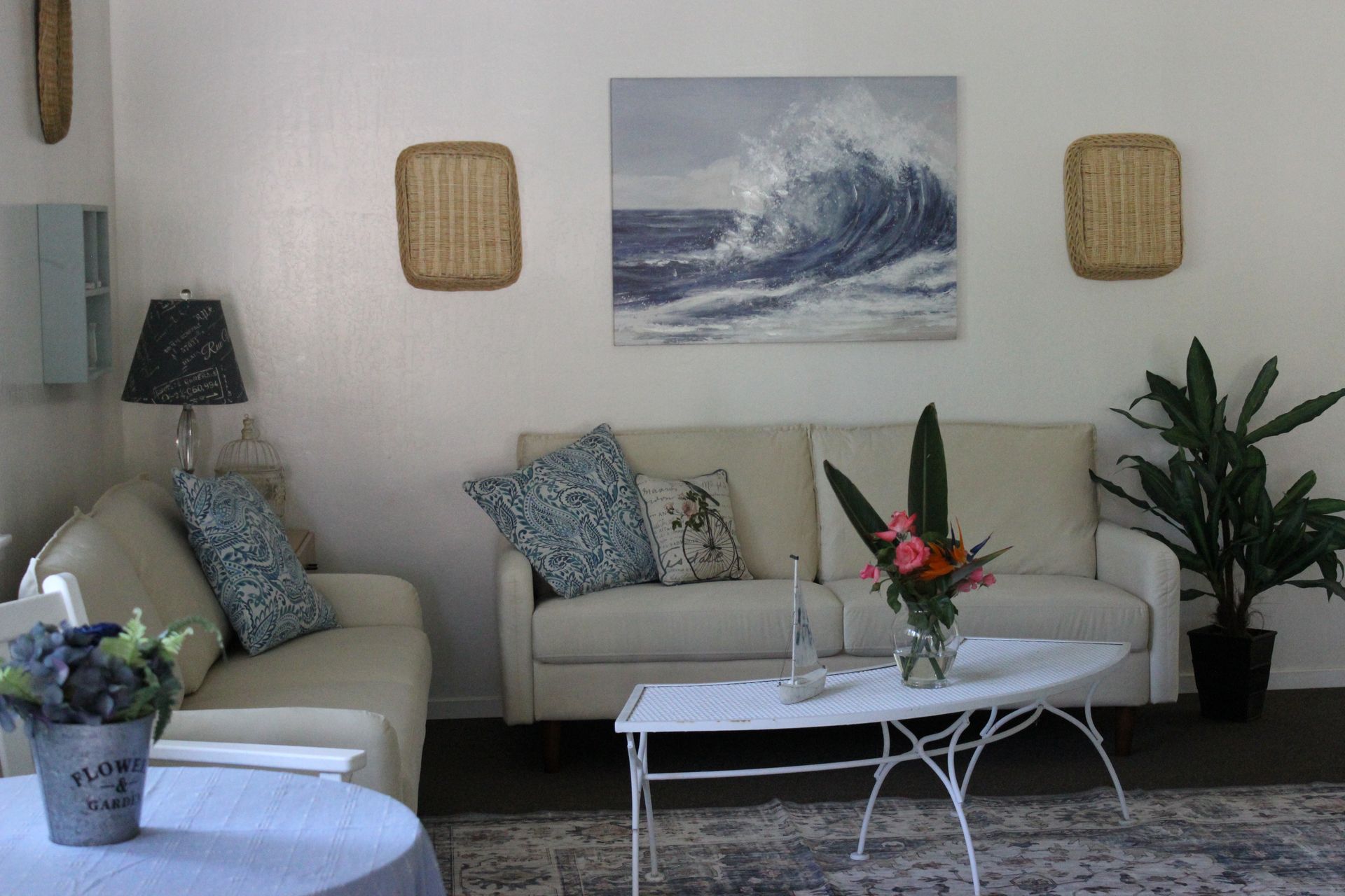 A living room with two couches a table and a painting on the wall
