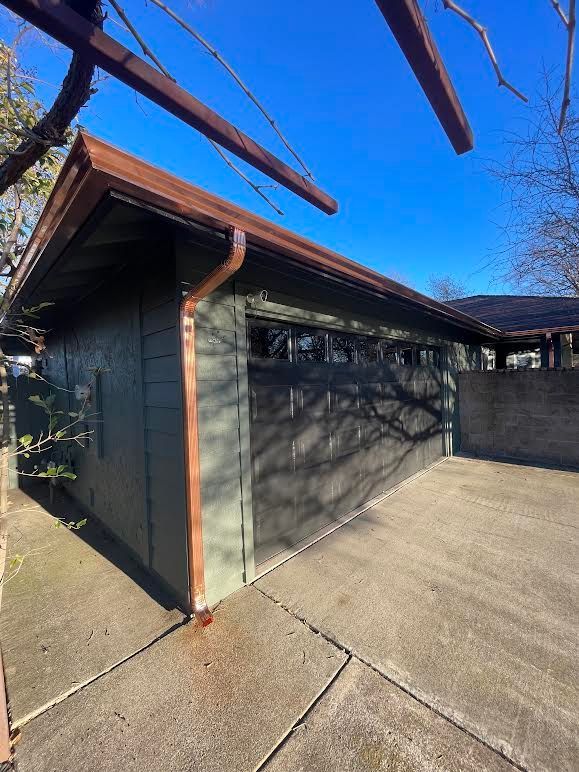 A garage with a copper gutter on the side of it.