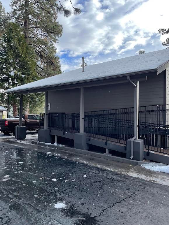 A truck is parked in front of a building with a covered porch.