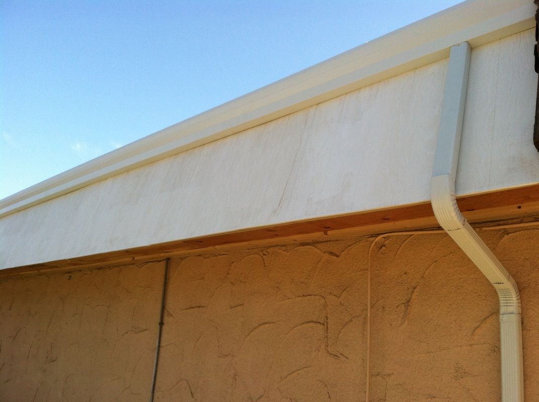 A white gutter on the side of a building