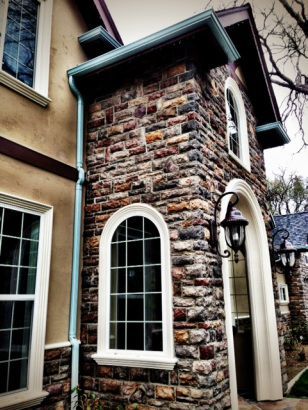 A brick building with arched windows and a blue gutter