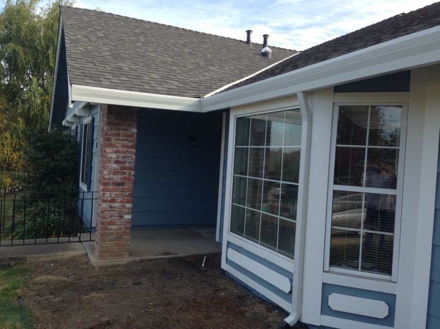 A blue and white house with a large window