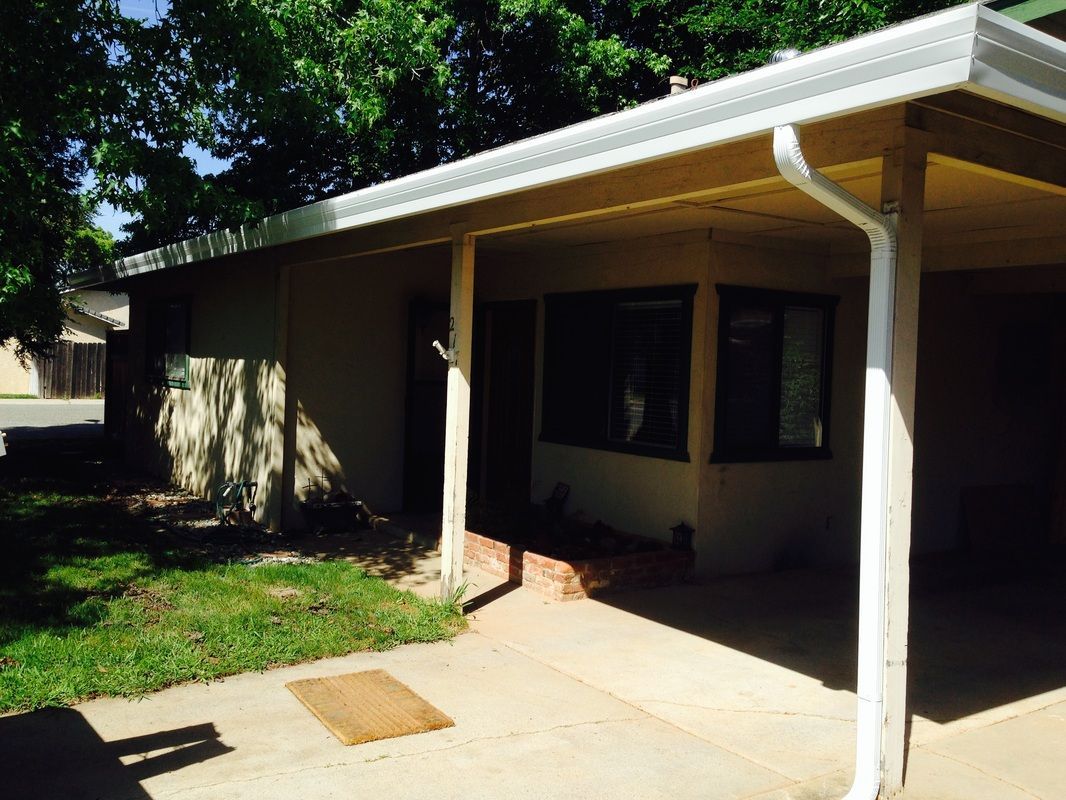A house with a covered porch and a white gutter