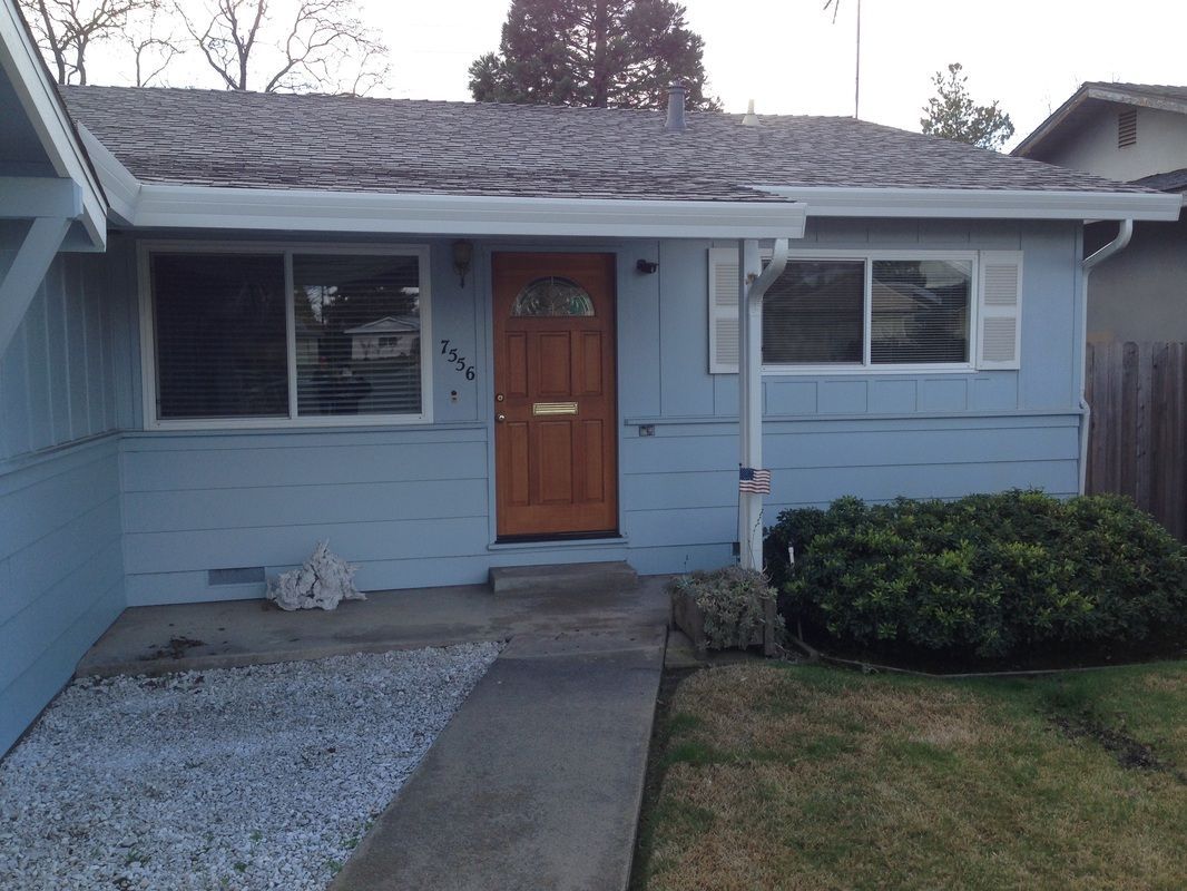 A blue house with a brown door and windows