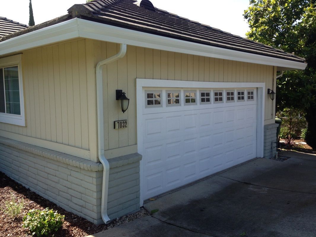 A yellow house with a white garage door