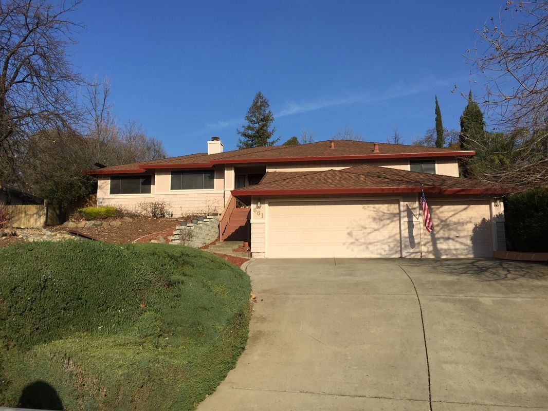 A large house with a garage and a driveway in front of it.