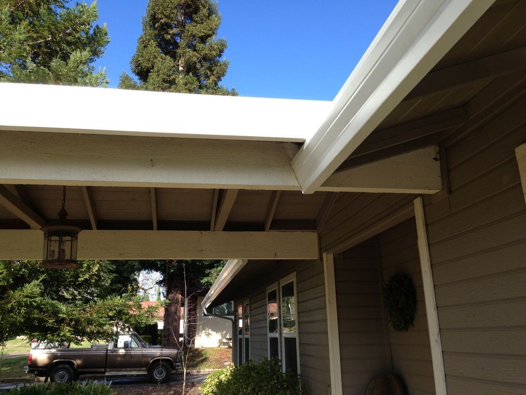A truck is parked under the porch of a house