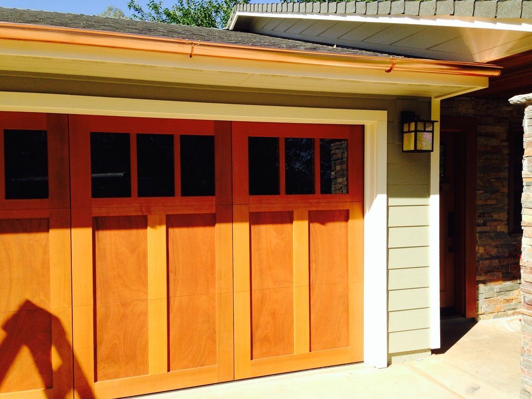 The garage door is made of wood and has a lot of windows