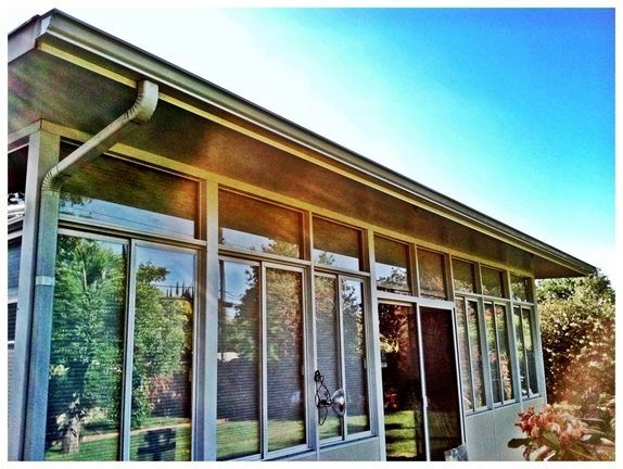 A house with a lot of windows and a blue sky in the background
