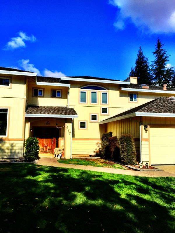 A large yellow house with a blue sky in the background