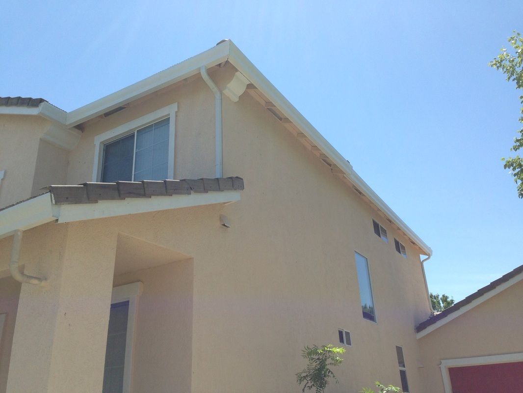 A beige house with a blue sky in the background