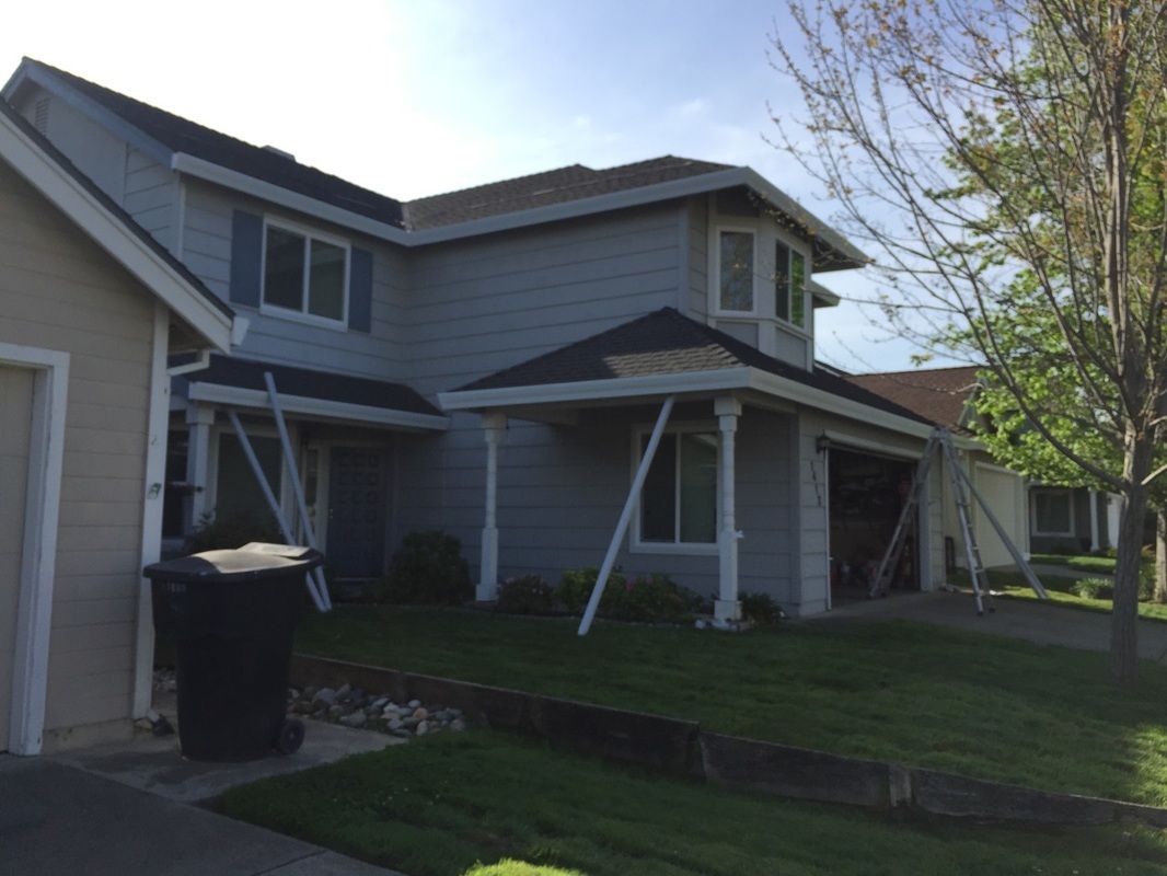 A house with a black trash can in front of it