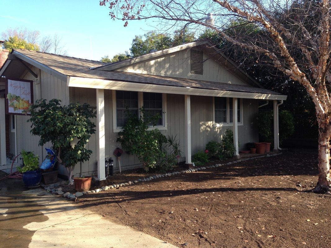 A house with a porch and trees in front of it
